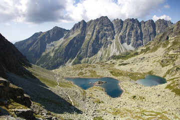 Mountain landscape. European mountains Tatras mountains. Mountains tops in the clouds, blue sky. The Tatra Mountains. The tops of the mountain and lakes below.