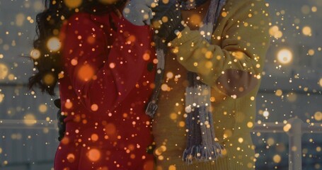 Standing daughter and father wearing coats on rooftop terrace, with metal railing and golden lights