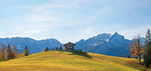alpine hut Eckbauer mountain upon the hill, Wetterstein alps with Alpspitze mountain, autumnal landscape