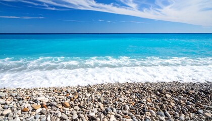 Sparkling turquoise waters meet a pebble beach under a vibrant sky