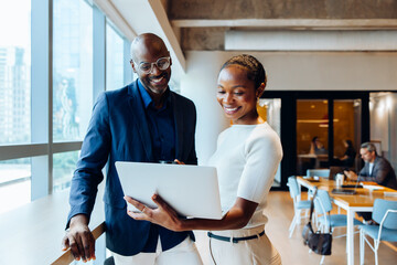 Professionals discussing ideas with a laptop in a bright office space