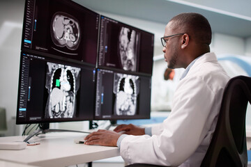 Skilled Surgeon Analyzing MRI Scan Using Desktop Computer