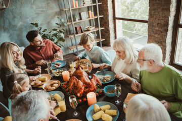 A warm family thanksgiving dinner around a big turkey with generations gathering together for a festive holiday