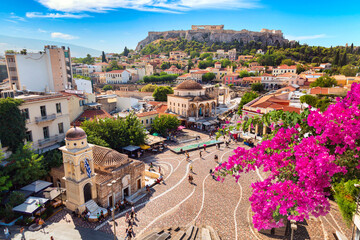 Skyline of Athens with Monastiraki square, Church of Pantanassa and Acropolis hill during summer sunny day. Athens, Greece. Pink bougainvillea flower in the foreground.