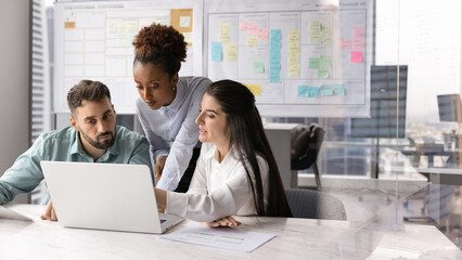 International business team developing project on notebook in Agile office