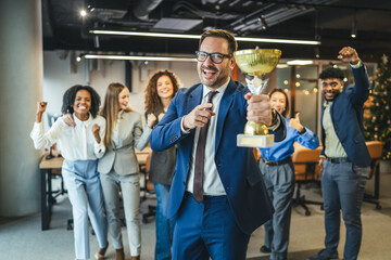 Business team celebrating achievement with a winning trophy
