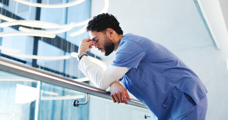 Nurse, man and sad with stress in clinic for grieving loss, operation failure and medical trauma. Low angle, health professional and unhappy in hospital hallway for healthcare crisis and overwhelmed
