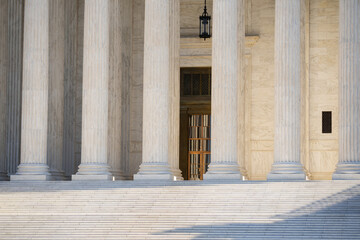 White stone columns express civic architecture. Supreme Court columns suggest justice and authority. Marble pillars highlight timeless architecture. Historic government building with massive columns.