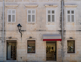 Stare zabytkowe kamienice i uliczki w mieście Trogir w Chorwacji z pięknymi oknami i okiennicami. 