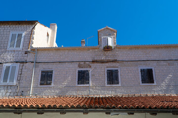 Stare zabytkowe kamienice i uliczki w mieście Trogir w Chorwacji z pięknymi oknami i okiennicami. 