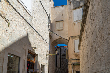 Stare zabytkowe kamienice i uliczki w mieście Trogir w Chorwacji z pięknymi oknami i okiennicami. 