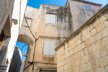 Stare zabytkowe kamienice i uliczki w mieście Trogir w Chorwacji z pięknymi oknami i okiennicami. 