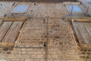 Stare zabytkowe kamienice i uliczki w mieście Trogir w Chorwacji z pięknymi oknami i okiennicami. 