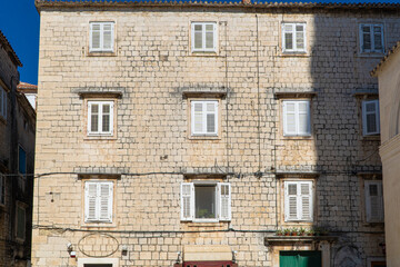 Stare zabytkowe kamienice i uliczki w mieście Trogir w Chorwacji z pięknymi oknami i okiennicami. 