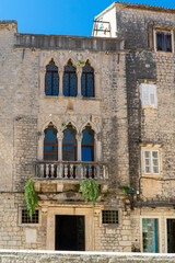 Stare zabytkowe kamienice i uliczki w mieście Trogir w Chorwacji z pięknymi oknami i okiennicami. 