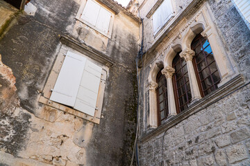 Stare zabytkowe kamienice i uliczki w mieście Trogir w Chorwacji z pięknymi oknami i okiennicami. 