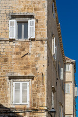 Stare zabytkowe kamienice i uliczki w mieście Trogir w Chorwacji z pięknymi oknami i okiennicami. 