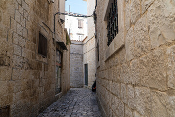 Stare zabytkowe kamienice i uliczki w mieście Trogir w Chorwacji z pięknymi oknami i okiennicami. 