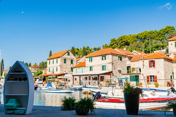 Miasto Maslinica na wyspie Solta w Chorwacji. Tradycyjna zabudowa i wąskie uliczki. Domy z czerwoną dachówką.