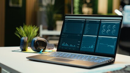 Modern laptop showcasing data reports in an empty office late at night, performance metrics and forecasting graphs. Corporate workspace equipped with technology to reflect business management.