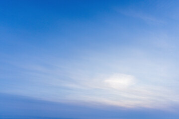 A tranquil blue sky fades through soft clouds