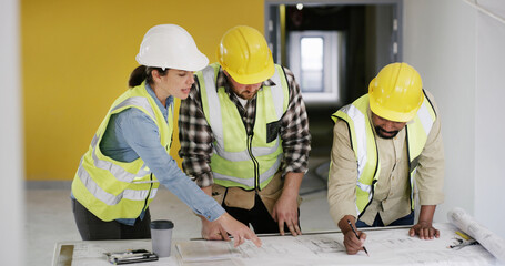 People, architect and blueprint with team at meeting, writing and point with solution for building. Group, contractor and engineer with floor plan, talk and insight at property development company