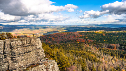 Enjoy the vibrant autumn colors from the lookout at Southern Terraces in Stolowe Mountains National Park. The layered landscape features sandstone formations and lush forests.
