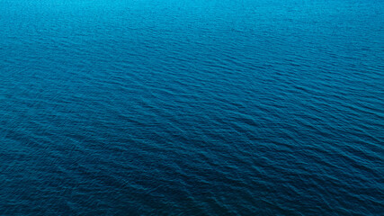 Top view of deep blue sea water surface with small ripples, aerial drone shot of turquoise ocean texture at island , abstract nature background 