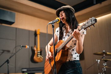 Young asian music group Band members rehearse with instruments guitar bass drum. Teamwork music band practice in studio prepire perform. Vocalist and band