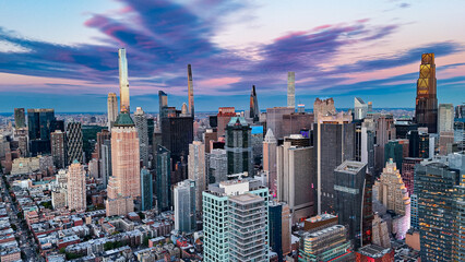 Midtown Manhattan skyline at colorful sunset. Aerial view of Midtown Manhattan skyscrapers under dramatic sunset sky.