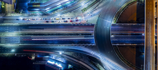 Expressway top view, Road traffic an important infrastructure, car traffic transportation above intersection road in city night, aerial view cityscape of advanced innovation, financial technology
