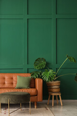 Interior of living room with brown sofa, pouf and palm plant