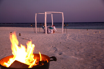 Romantic Beach Wedding Setup with Bonfire at Maldives Sunset