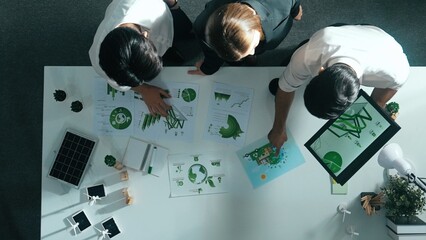 Top view of manager hold tablet display clean energy investment at meeting. Aerial view of skilled business team working together and planning to use sustainability environmental energy. Alimentation.