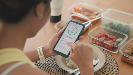 Young adult black asia people active gen z using AI phone record data daily meal tracker clean food diet app control. Asian Smart living care happy life goal routine plan lunch time home dining table.