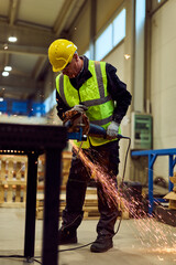 Industrial Worker Grinding Metal in Workshop With Safety Vest and Hard Hat Creating Sparks