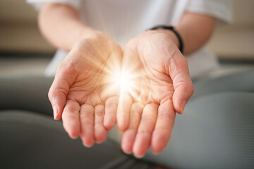 Give to Gain Symbol of Empowerment and Sharing. Woman Holding a Glowing Light in Her Open Hands While Sitting in Yoga Lotus Pose