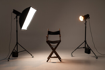 Film director chair between studio lights on professional photography set