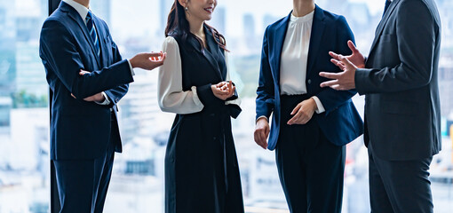 オフィスで会話する日本人ビジネスチームのミーティング風景