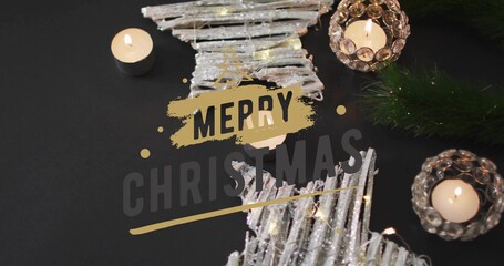 Shining star ornaments lying on black table, with tealight pine sprig fairy lights Merry Christmas