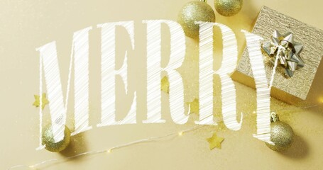 Displaying large white 'MERRY' lettering on gold tabletop with gold baubles, present, string lights