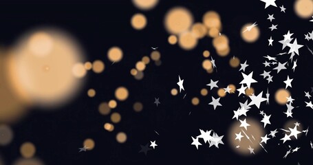 Sparkling clustered white star confetti drifting right of black backdrop, with warm bokeh lights
