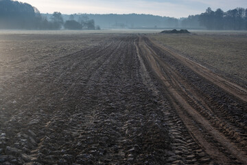 Zaorane pole z charakterystyczną ziemią - typowy wczesnowiosenny wiejski krajobraz