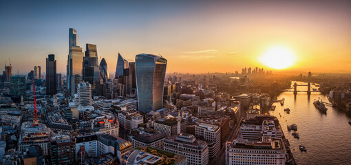 Panoramic aerial view of the City of London, UK, skyline during sunrise with office skyscrapers and river Thames