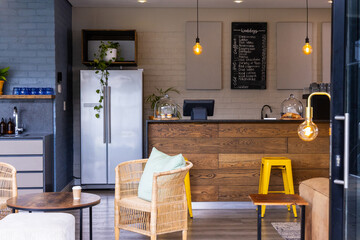 Wooden service counter occupying center, displaying pastries in glass domes under pendant lights