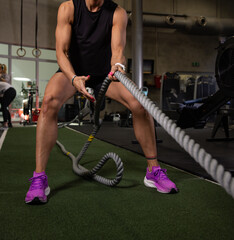 Fitness and health concept. A fit young woman works out in a modern gym. Athletic man doing exercise.