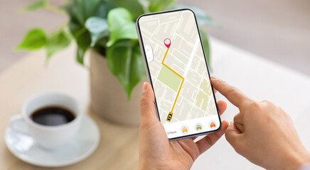 Cropped of woman using navigation mobile app on smartphone, using tracking service, order taxi online. Unrecognizable lady drinking coffee at home, waiting for cab, panorama