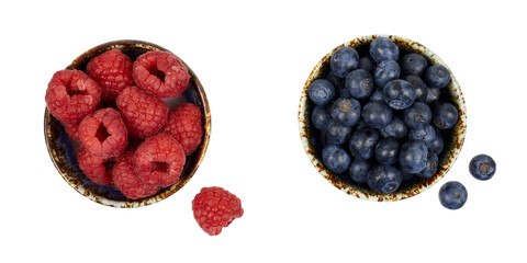 two bowls of fresh raspberries and blueberries ioslated on white or transparent png