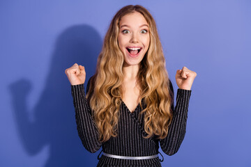 Young woman with long blonde hair in a striped jumpsuit celebrates with a joyful smile against a violet background for fashion lifestyle promotion shopping