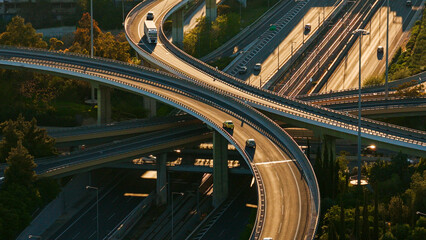 Complex road infrastructure featuring a multi-level highway interchange with many vehicles traveling on various bridges and ramps, highlighting modern connectivity and the flow of traffic